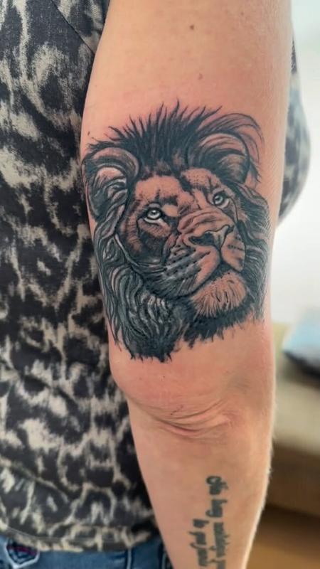 Cover up de cabeza de león en blanco y negro en la parte trasera del brazo