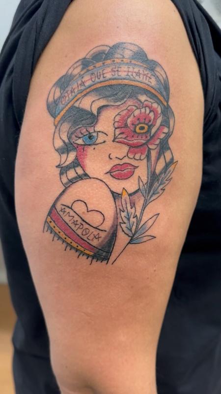 Tatuaje old school a color en el brazo: rostro de mujer con una amapola y la palabra Amapola