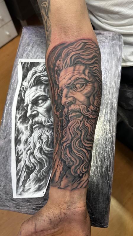 Tatuaje realista de Zeus en el antebrazo en blanco y negro